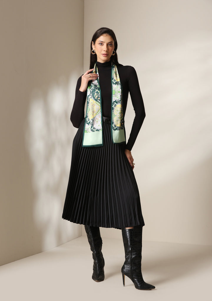 Woman wearing a botanical paisley silk scarf styled over a black turtleneck and pleated skirt